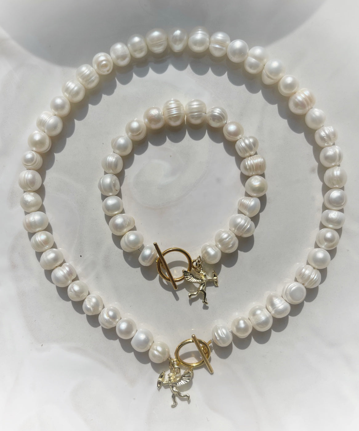 White pearl charm necklace and bracelet matching set with dainty gold Cupid / cherub charm, classic white pearl jewelry, summer jewelry