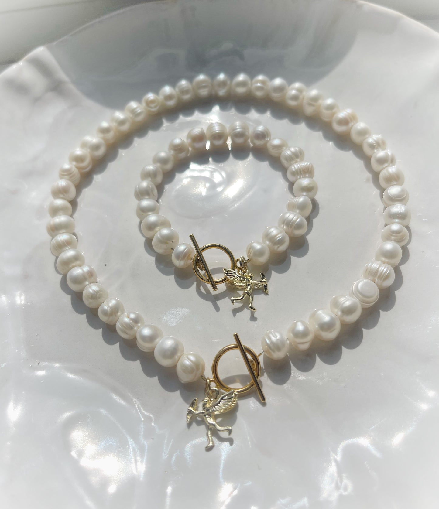 White pearl charm necklace and bracelet matching set with dainty gold Cupid / cherub charm, classic white pearl jewelry, summer jewelry